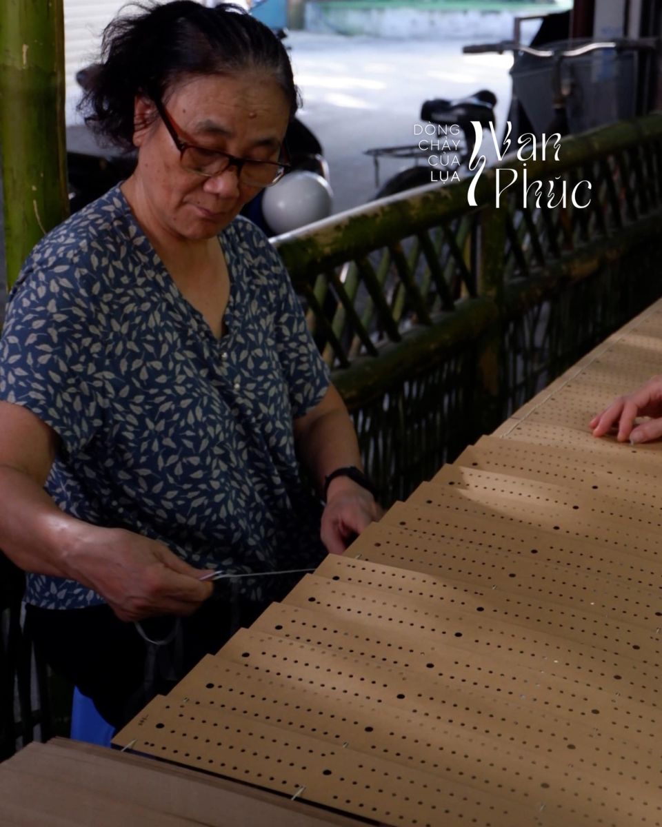 Thợ đang xâu mẫu bìa cacton trước khi dệt lụa